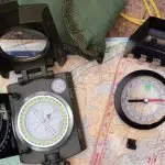 Image featuring a lensatic and a baseplate compass.