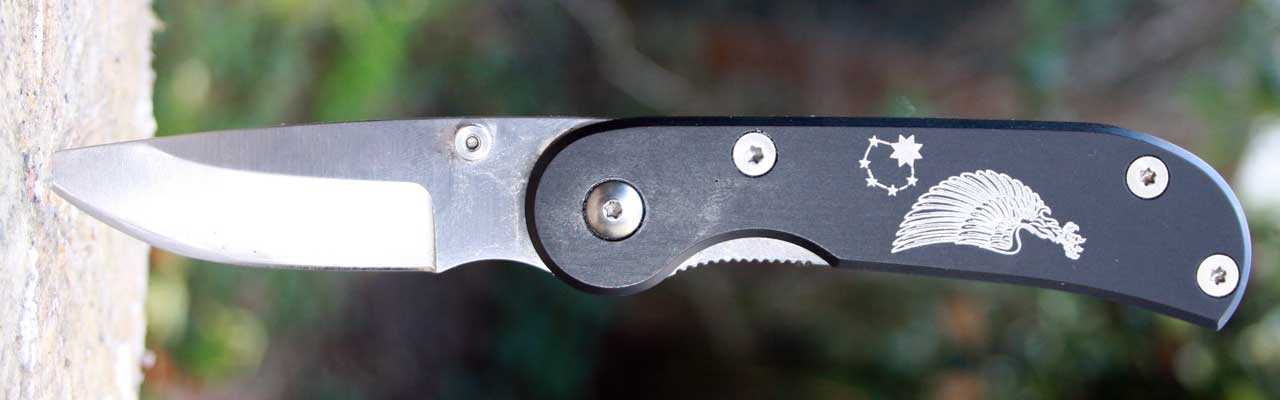 Photo of a folding knife on a log.