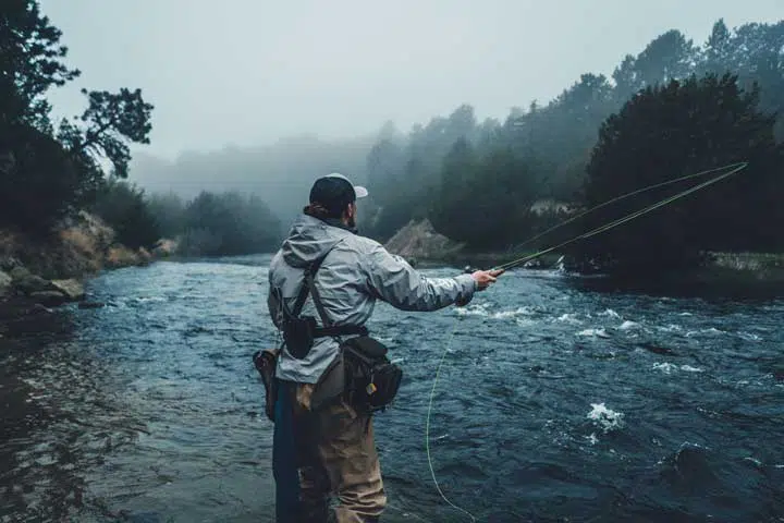 Photo of a fisherman fishing in a river. 