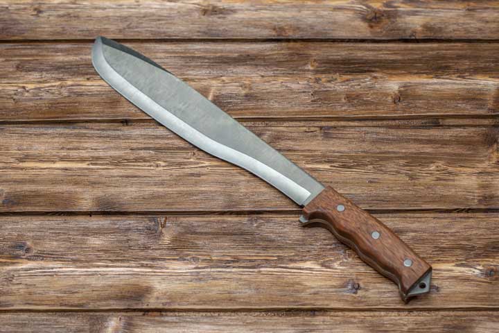 Photo of a machete on a wooden bench.