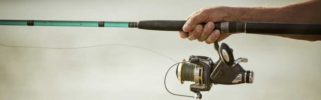 Photo of the detail of a baitcaster combo while being used for fishing.