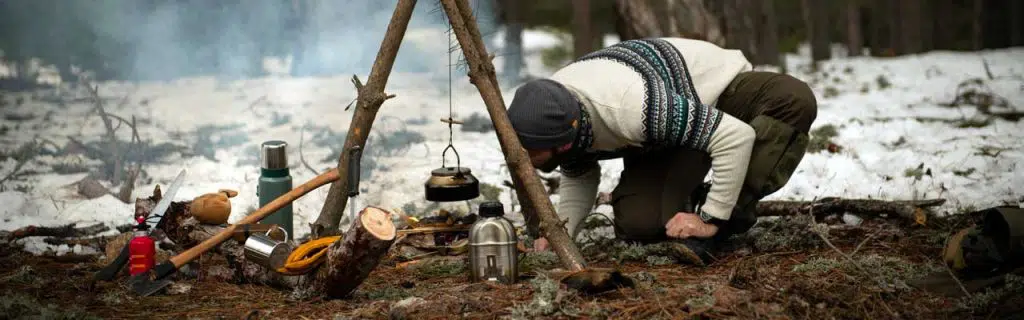 photo of a bushcrafter blowing on the fire.
