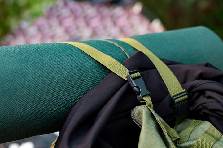 green camping mat attached to camping bag. 