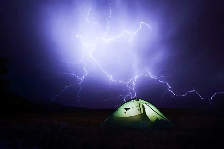 Photo of a tent in the middle of a thunderstorm. 