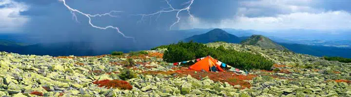 Photo of a tent in the middle of a thunderstorm. 