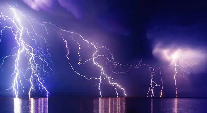 Photo of a thunderstorm with lightning coming from the water. 