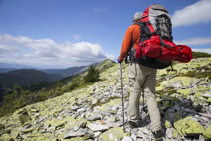 Summer hiking in the mountains with a backpack and tent. 