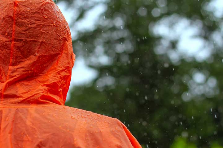 Men wear orange windbreaker in the rain. 