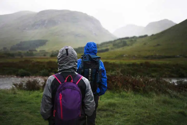 Couple trekking through the rain in the Highlands