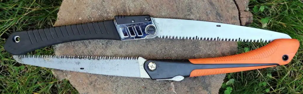 Two bushcraft foldable saws on a log.