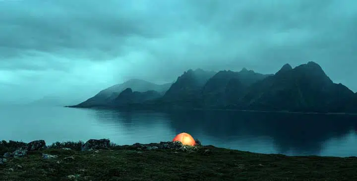 Illuminated tent at the lofoten islands on the rainy evening.