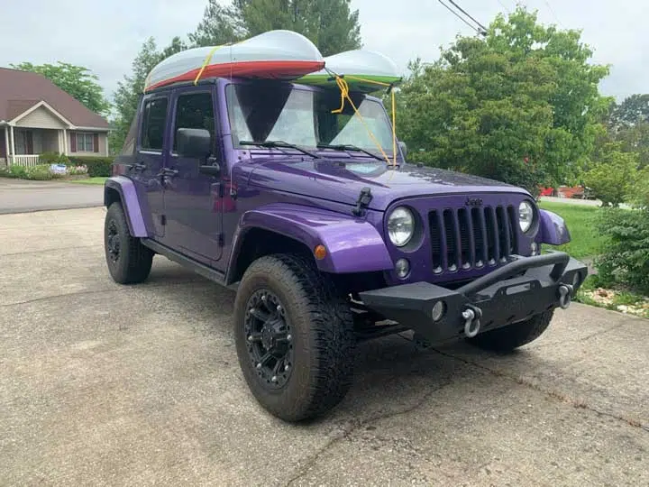 Jeep with two kayaks on the roof. 