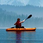 Man with canoe on the lake.