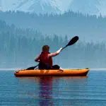 Man with canoe on the lake.