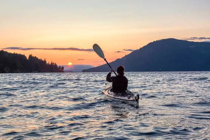 Adventurous Woman on Sea Kayak paddling in the Pacific Ocean. 