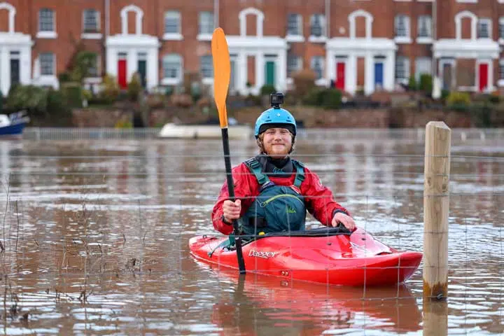 kayaker makes the most of the flood water in the River Dee. 
